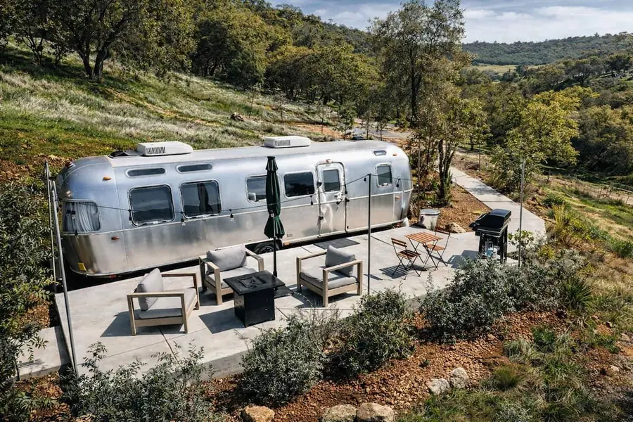 Airstream with a large furnished patio on a hillside above the foothills