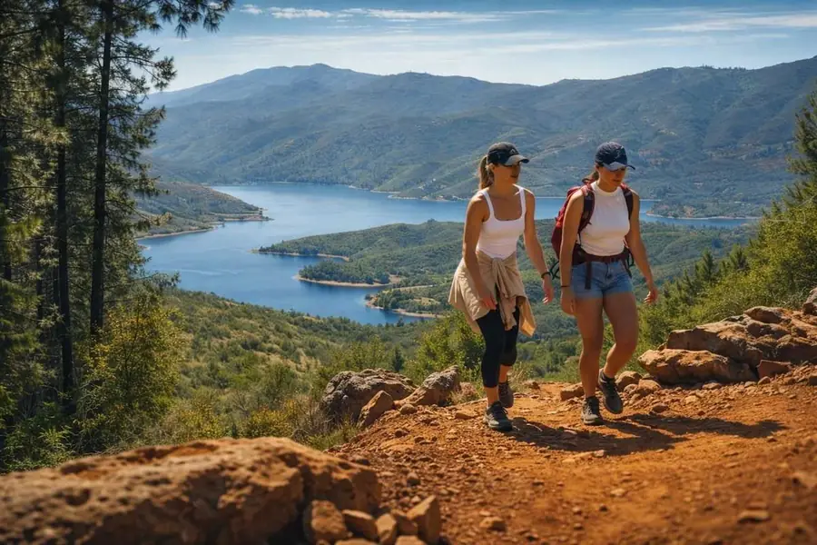 Two hikers on a ridge trail above Lake McClure