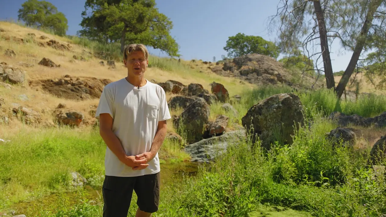 A host standing by the second spring at the old Wells Fargo water trough, telling its history
